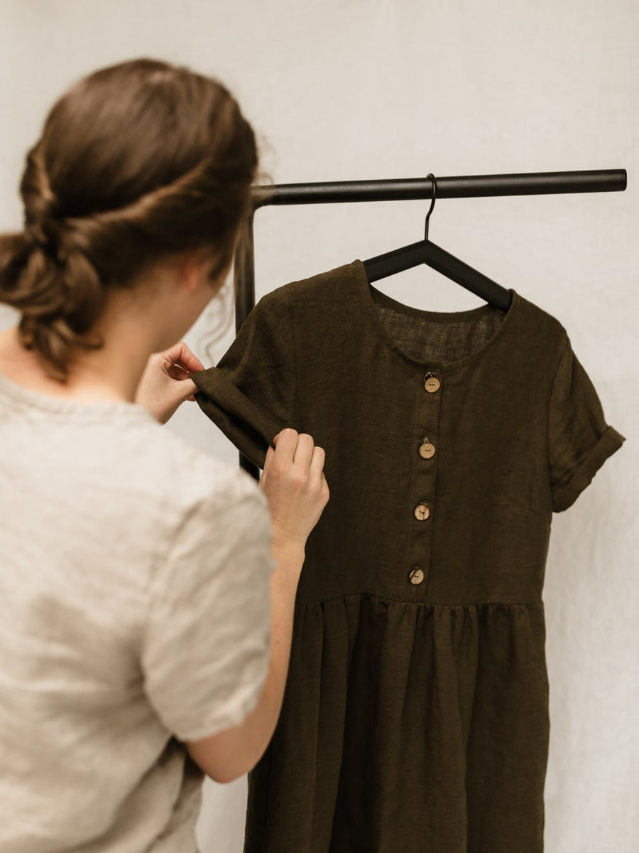 A handmade linen dress with gathered waist, buttons, and pockets. Perfect for the sustainable closet. Make with high quality, linen fabric and sizes can be customized.