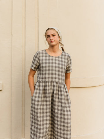 The Aaro smock is a handmade linen dress featuring a more structured bodice, including a set in sleeve and side bust darts, with an easy flowing skirt. The gathered waist skirt includes hidden side seam pockets.