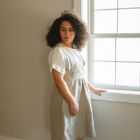 The Asa jumper features a crossed front bodice and plain back. The top of the dress is doubled for a clean finish and added durability. The gathered skirt includes hidden side seam pockets. Perfect for the sustainable closet. Made with quality linen. Customizable sizes.