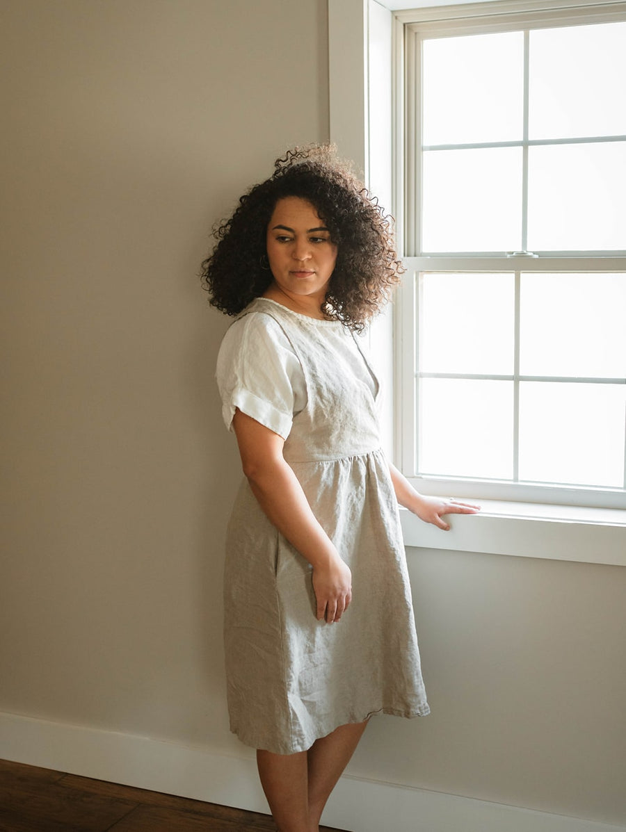 The Asa jumper features a crossed front bodice and plain back. The top of the dress is doubled for a clean finish and added durability. The gathered skirt includes hidden side seam pockets. Perfect for the sustainable closet. Made with quality linen. Customizable sizes.